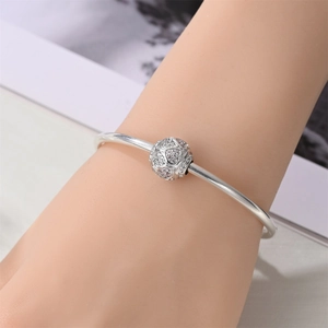 Close-up of silver beaded bracelet featuring pavé heart charm with white cubic zirconia