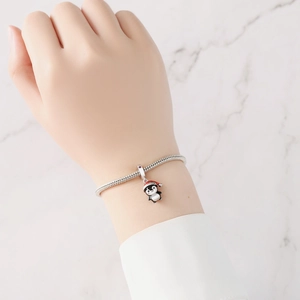 Pulsera de plata con dije de pingüino festivo llevando un gorro rojo de Navidad