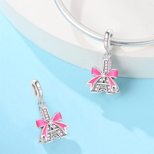 Detailed view of Eiffel Tower charm with pink enamel bow and crystals on silver bracelet