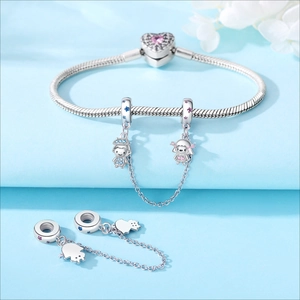 Detalle de pulsera de dijes de plata S925 con cierre de corazón rosa y colgantes infantiles