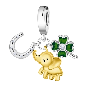 Macro shot of silver horseshoe, gold elephant, and green clover lucky jewelry charms