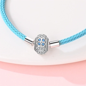 Makroaufnahme von blauem Lederarmband mit silberner Hohlperle und blauen Zirkonias