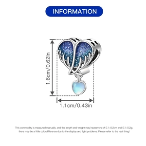 Detalle del dije de corazón en plata con esmalte azul estrellado y gota en degradado