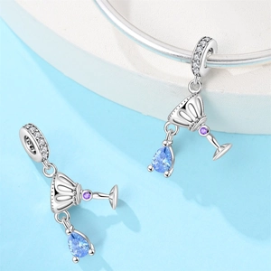 Macro detail of wine glass charms with blue teardrop stones and silver craftsmanship