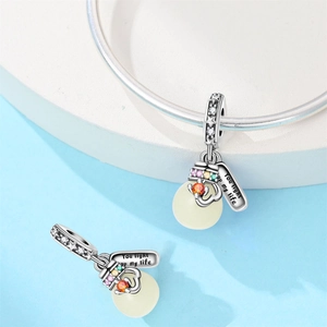Close-up of silver charm with colorful stones and You Light Up My Life engraving