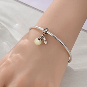 Detailed view of silver open bangle with 'You light up my life' engraved charm