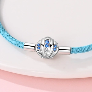 Nahaufnahme des blauen Lederarmbands mit silbernem Muschel-Anhänger und Zirkonia