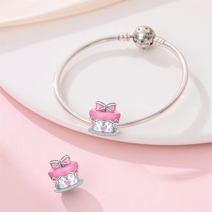 Detail of s925 silver pink enamel birthday cake charm on bracelet with heart engraving