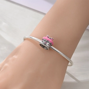 Detailed view of pink cupcake charm with purple zircon on silver bracelet band
