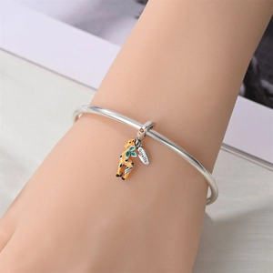 Detail of silver giraffe charm bracelet with yellow enamel and orange zircon stone