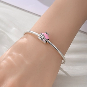 Detail of silver crown birthday cake charm with pink enamel and Happy Birthday engraving