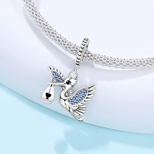 Makroaufnahme von Storchanhänger mit blauen Kristallen und Herz auf Silberarmband