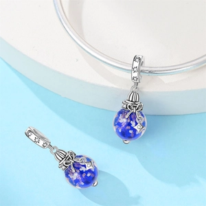 Macro view of blue starry glass charm with silver star pendant on a bracelet