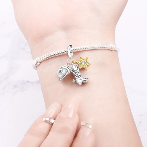 Detaillierte Makroansicht eines Cowboy-Charm-Armbands mit Hut-, Stiefel- und Sternanhängern
