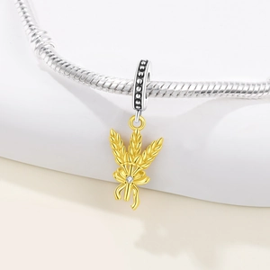 Makro-Detail eines goldenen Weizenähren-Anhängers mit Diamant an silberner Schlangenkette