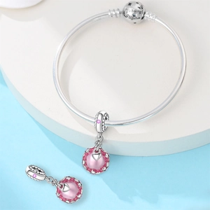Vue macro d'un bracelet en argent avec breloque cœur rose et gravure 'We belong together'