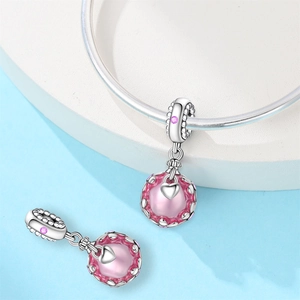 Détail de perle de cristal rose avec cage cœur en argent sur un bracelet