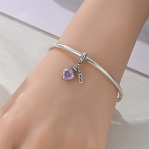Gros plan d'un bracelet en argent avec pendentif cœur violet et étiquette Wish gravée