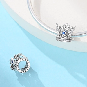 Detail of silver crown charm with blue zircon and King of the forest engraving