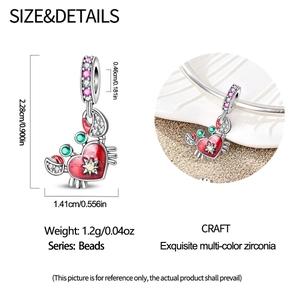 Detail of crab charm bead with red heart design and inlaid green zircon eyes for bracelets