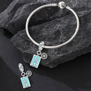 Macro view of Tarot The Chariot charm with blue enamel on a silver bangle bracelet