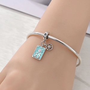 Macro shot of silver chariot tarot charm with blue enamel on a sliding charm bracelet