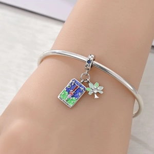 Detail of The Magician tarot card charm with colorful enamel on a silver-plated bracelet