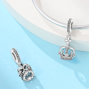 Macro detail of silver crown charms with micro-paved zircons and Glory of Crown engraving
