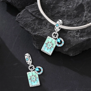 Detailed shot of Wheel of Fortune tarot charm with blue enamel and sparkling zircon stones