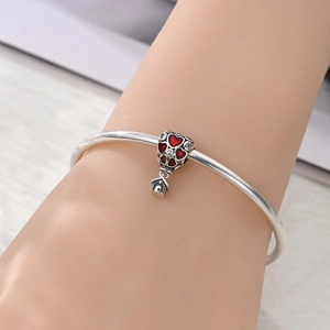 Detailed view of silver charm bracelet with a red heart hot air balloon and house pendant