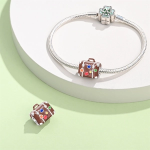 Close-up of a silver suitcase charm with colorful stickers and a green clover clasp