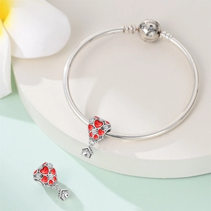 Detailed shot of silver heart balloon house charm with red enamel on bangle