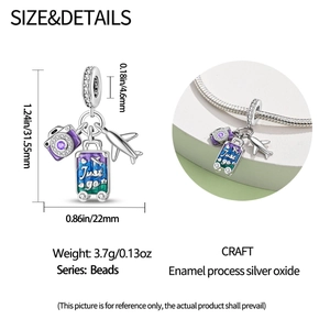 Macro detail of travel charms featuring airplane and suitcase on silver snake chain
