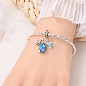 Detail showing silver travel charms with blue suitcase and passport on a snake chain