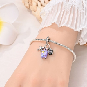 Silver snake chain bracelet with travel-themed charms like airplane, suitcase, and camera