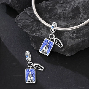 Macro detail of silver Death Tarot charm with blue enamel and sparkling zircon stones