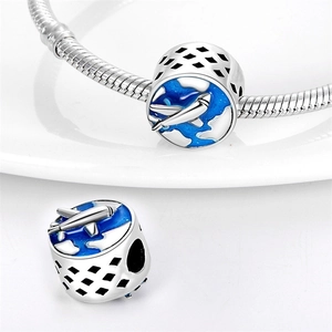 Macro detail of airplane charm bead with blue enamel sky and silver hollow design