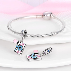 Detailed view of silver charm bracelet with colorful enamel camera pendants and crystals
