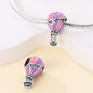 Macro detail of silver hot air balloon charm with pink enamel and purple zircons