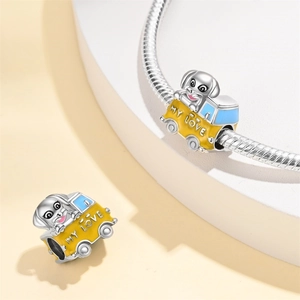 Macro shot of silver puppy car charm with yellow enamel and MY LOVE engraving on a chain