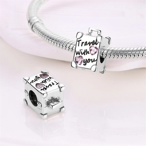 Detailed silver suitcase charm with pink heart gems and Travel With You engraving