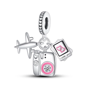Detailed macro view of silver charms featuring airplane, camera and heart photo frame