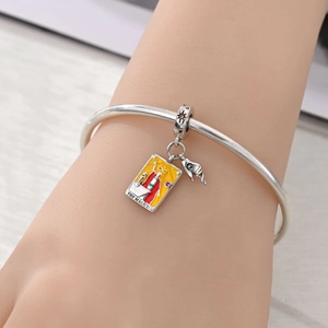 Close-up of The Magician tarot charm on a silver bracelet with vibrant enamel detail