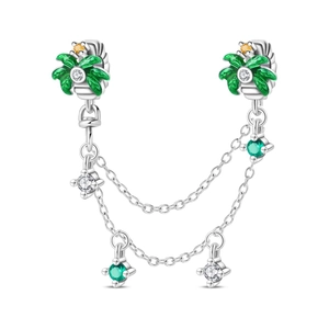 Detail of silver palm tree charm with green enamel and dangling gemstone chains
