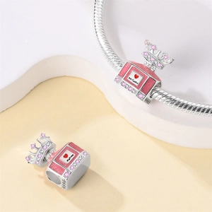 Macro detail of crown perfume bottle charm with pink enamel and crystals on a snake chain