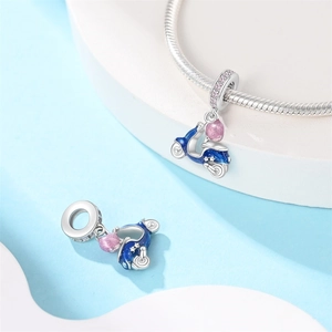 Detailed macro view of vintage blue scooter charm with pink glitter seat on silver chain