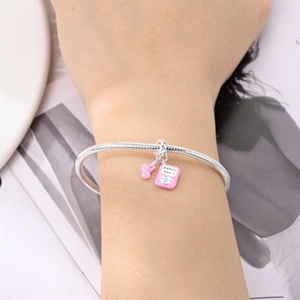 Vue détaillée du bracelet en argent avec breloque lecteur MP3 en émail rose et écouteurs