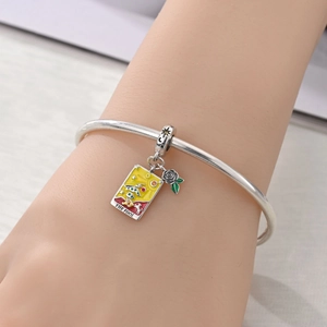 Macro shot of silver Tarot charm with 'The Fool' enamel card and rose dangle on bracelet
