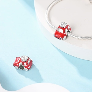 Detailed close-up of red enamel car charm bead on silver snake chain bracelet