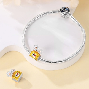 Macro detail of S925 sterling silver perfume bottle charm and engraved daisy pendant